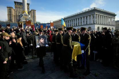 A serviceman carries a photo of Ukrainian officer Dmytro Kotsiubaylo  during a commemoration ceremony in Independence Square in Kyiv, Ukraine, on March 10, 2023.