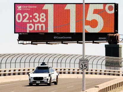A Waymo self-driving car drives on Seventh Street as the temperature of 115 degrees is displayed on a digital billboard in downtown Phoenix, Arizona, on July 17, 2023.
