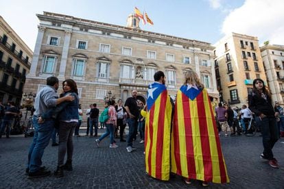 Two people with the pro-independence flag on Saturday outside the Palau de la Generalitat.
