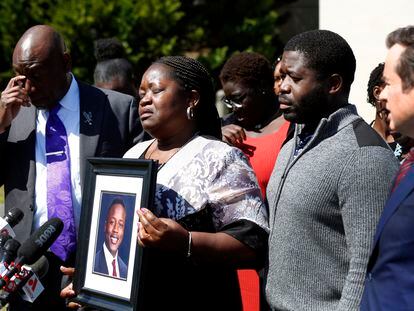 Caroline Ouko, mother of Irvo Otieno, holds a portrait of her son with attorney Ben Crump, left, her older son, Leon Ochieng and attorney Mark Krudys at the Dinwiddie Courthouse in Dinwiddie, Va., on Thursday, March 16, 2023.