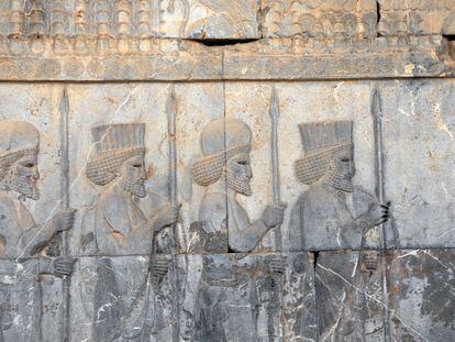 An ancient wall depicting four Assyrian warriors with spears, in Persepolis, Iran.