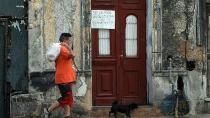 A man walking past a home up for sale in Havana, Cuba.