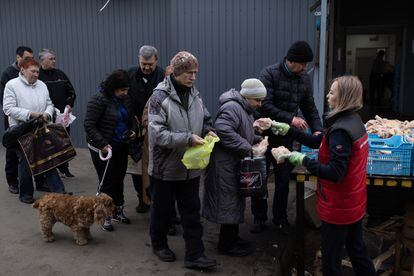 Dozens of people line up to receive food in a neighborhood of Kharkiv.