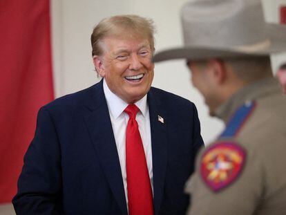 Republican presidential candidate and former U.S. President Donald Trump laughs with a DPS trooper during a Thanksgiving luncheon in Edinburg, Texas. November 19, 2023.