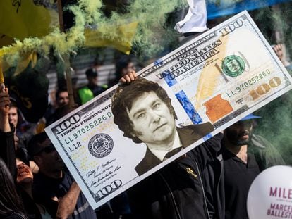 A supporter of Javier Milei holds a replica of a U.S. dollar bill with the portrait of the president.