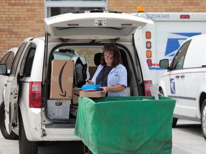 A United States Postal Service (USPS) worker loads mail into a delivery truck at the post office in Royal Oak, Michigan, U.S. August 17, 2020.