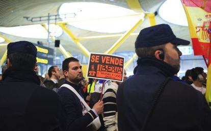 A protestor carries a banner reading &quot;Iberia for sale&quot; during a strike by Iberia airline employees at Madrid airport in Madrid on Monday.