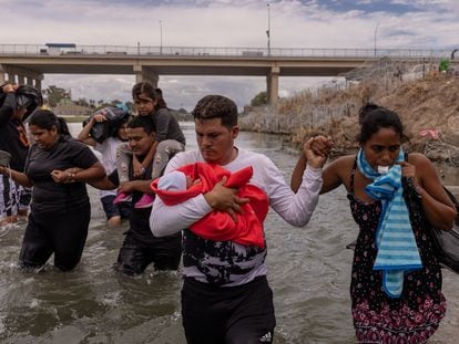 A group of people crosses the Rio Grande, the natural border between the United States and Mexico, on October 6.