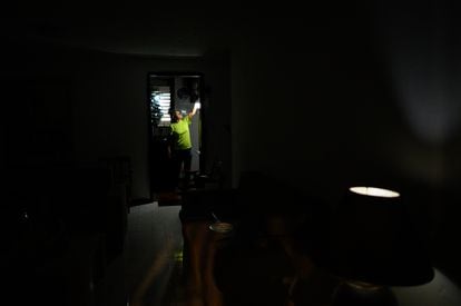 Carolina González turns on a rechargeable light bulb in the kitchen of her home during an electrical service failure, September 7.