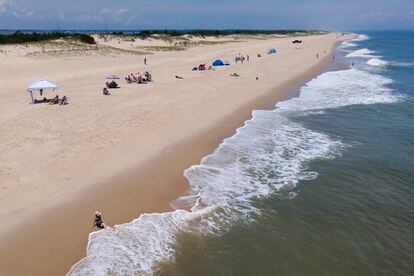 Waves crash near a beachgoer on July 13, 2022, in Rehoboth Beach, Delaware.