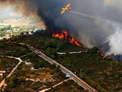A plane dumps water on the flames in Jávea.