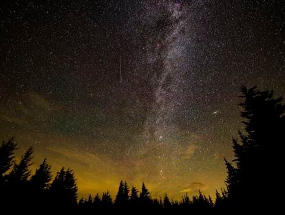 In this 30 second cameras exposure, a meteor streaks across the sky during the annual Perseid meteor shower, Wednesday, Aug. 11, 2021, in Spruce Knob, West Virginia