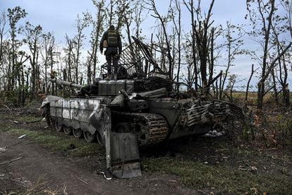 A Ukrainian soldier stands on an abandoned Russian tank on the edge of Izyum, in the Kharkiv region.