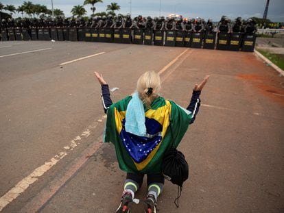 A Bolsonaro supporter prays before a police cordon after the assault on government headquarters in Brasília.