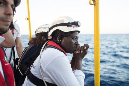 The ship’s midwife looks with concern at one of the unseaworthy rubber dinghies used by the migrants.