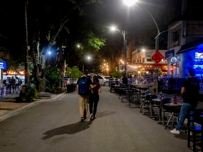 A couple walks through the streets of downtown Medellín (Colombia), in May 2023.