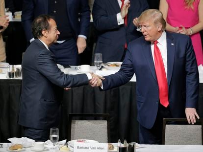Donald Trump (r) shakes hands with John Paulson during a meeting of the Economic Club of New York in New York, Nov. 12, 2019.