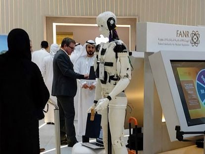 Visitors at the Gitex Global technology fair in Dubai converse alongside a robot in October.