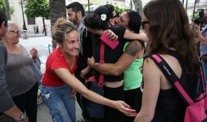Members of La Utopía community kiss and hug each other after receiving keys to new homes on Wednesday in Seville.