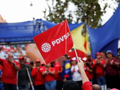 A woman holds a flag of the Venezuelan state oil company PDVSA while attending a rally against corruption and in support of the oil industry in Caracas, on March 25, 2023.
