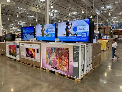 A shopper passes a display of televisions on sale in a Costco warehouse Thursday, June 22, 2023, in Colorado Springs, Colo.