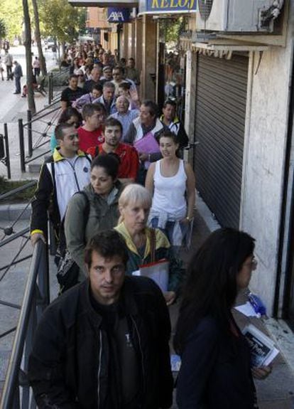Jobseekers stand in line outside an employment agency in Getafe.