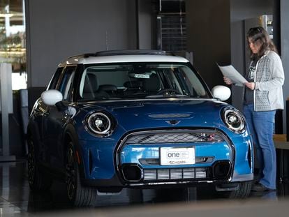 A potential buyer looks over an 2023 Cooper S sedan on the floor of a Mini dealership on Friday.