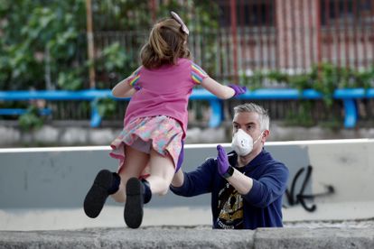 A father plays with his daughter in Madrid.