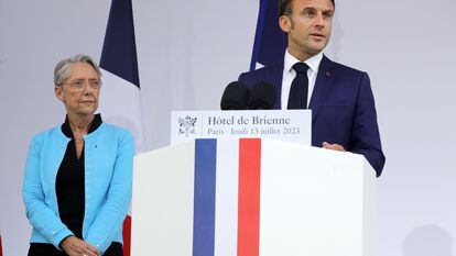 French President Emmanuel Macron flanked by Prime Minister Elisabeth Borne delivers his speech on the eve of Bastille Day, in Paris, France, 13 July 2023.