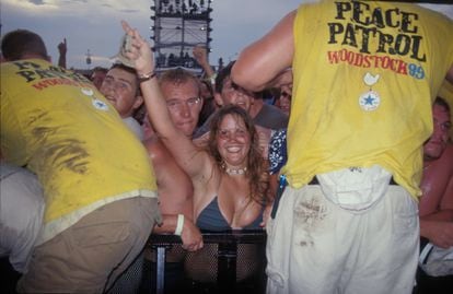 Woodstock ’99 attendees in the front row wave to the camera on July 22, 1999.