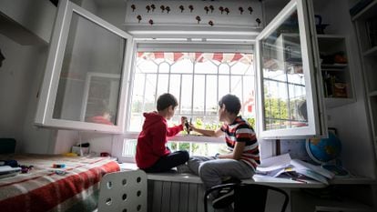 Two children play in the window of their Madrid home during the lockdown.