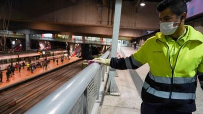 A worker cleans a railing at Atocha train station in Madrid.
