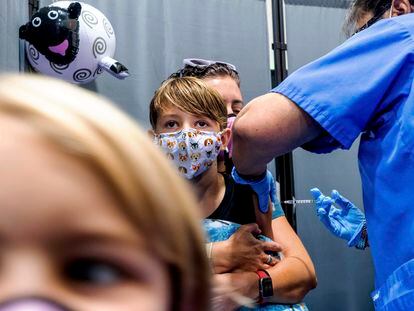 Finn Washburn, 9, receives an injection of the Pfizer-BioNTech COVID-19 vaccine in San Jose, Calif., on Nov. 3, 2021, as his sister, Piper Washburn, 6, waits her turn. California's COVID-19 emergency declaration ends on Tuesday, Feb. 28, 2023.