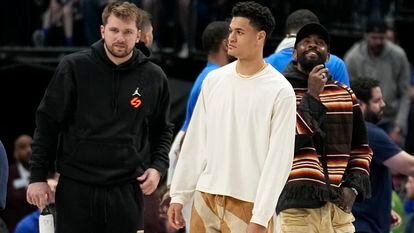 Dallas Mavericks' Luka Doncic, left, Josh Green, center, and Kyrie Irving, right, stand on the court during a timeout in the second half of an NBA game against the Chicago Bulls.