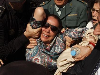 Spanish singer Isabel Pantoja is carried by the Spanish Civil Guard and police officers to a car after she collapsed while leaving court on Tuesday.