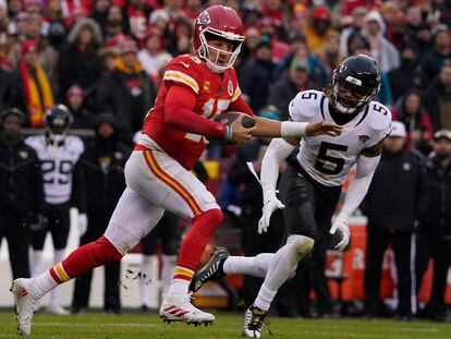 Kansas City Chiefs quarterback Patrick Mahomes (15) runs out of the pocket as Jacksonville Jaguars safety Andre Cisco (5) defends during the first half of an NFL divisional round playoff football game, Saturday, Jan. 21, 2023, in Kansas City, Mo.