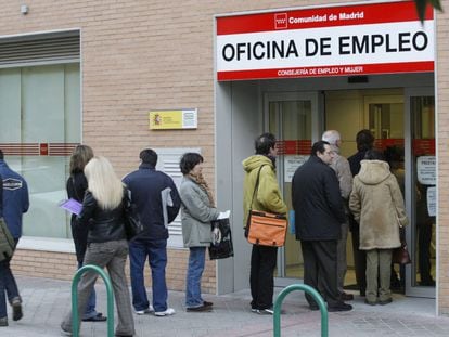 People stand in line outside a Madrid employment office.