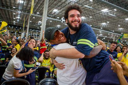 Two men celebrate a Brazil goal at a Mercado Libre distribution center.