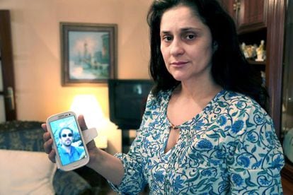 Julia Ordóñez, wife of police inspector José Antonio Martínez, who died on Sunday, holds up a cellphone image of her husband.