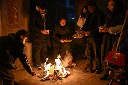 Wuhan residents burn offerings to pay tribute to relatives who passed away last year on Lunar New Year's Eve, January 21.