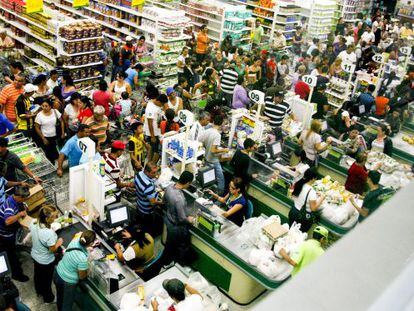 A group of people wait to purchase goods at a supermarket in San Cristóbal.
