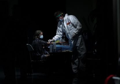 A health worker takes a blood sample from a woman at the Arts Center Auditorium in Arroyomolinos, Madrid.