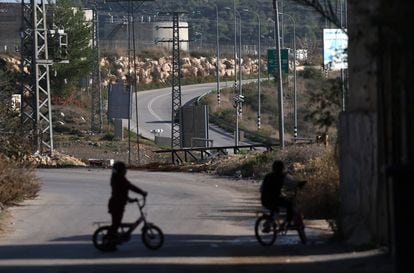 Two Palestinian girls ride a bicycle in Nabi Saleh, the village of Wisam Tamimi. In the background, the road to the illegal settler settlement of Halamish, where Palestinians are prohibited from traveling.