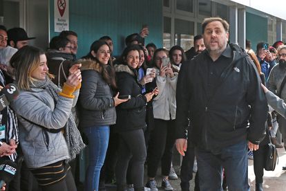 Students look on as Oriol Junqueras (r) arrives at Vic University.