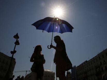 Tourists protect themselves from the heat in Puerta del Sol in downtown Madrid.