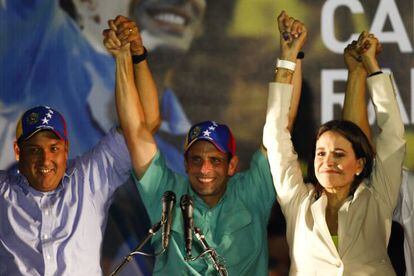 Presidential candidate Henrique Capriles raises his hands with Zulia state governor Pedro P&eacute;rez and independent candidate Mar&iacute;a Corina Machado in Caracas on Sunday. 