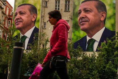 A person walks past billboards of Turkish President and People's Alliance's presidential candidate Recep Tayyip Erdogan a day after the presidential election day, in Istanbul, Turkey, on May 15, 2023.