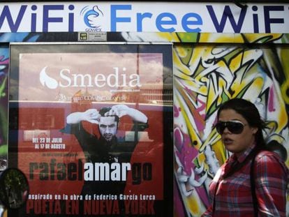 A woman walks past a newspaper kiosk joined to the Gowex wi-fi network in Madrid.