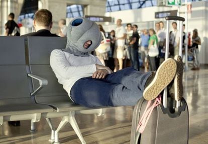 A traveler naps with the aid of the Madrid-designed Ostrich Pillow.