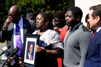 Caroline Ouko, mother of Irvo Otieno, holds a portrait of her son with attorney Ben Crump, left, her older son, Leon Ochieng and attorney Mark Krudys at the Dinwiddie Courthouse in Dinwiddie, Va., on Thursday, March 16, 2023.
